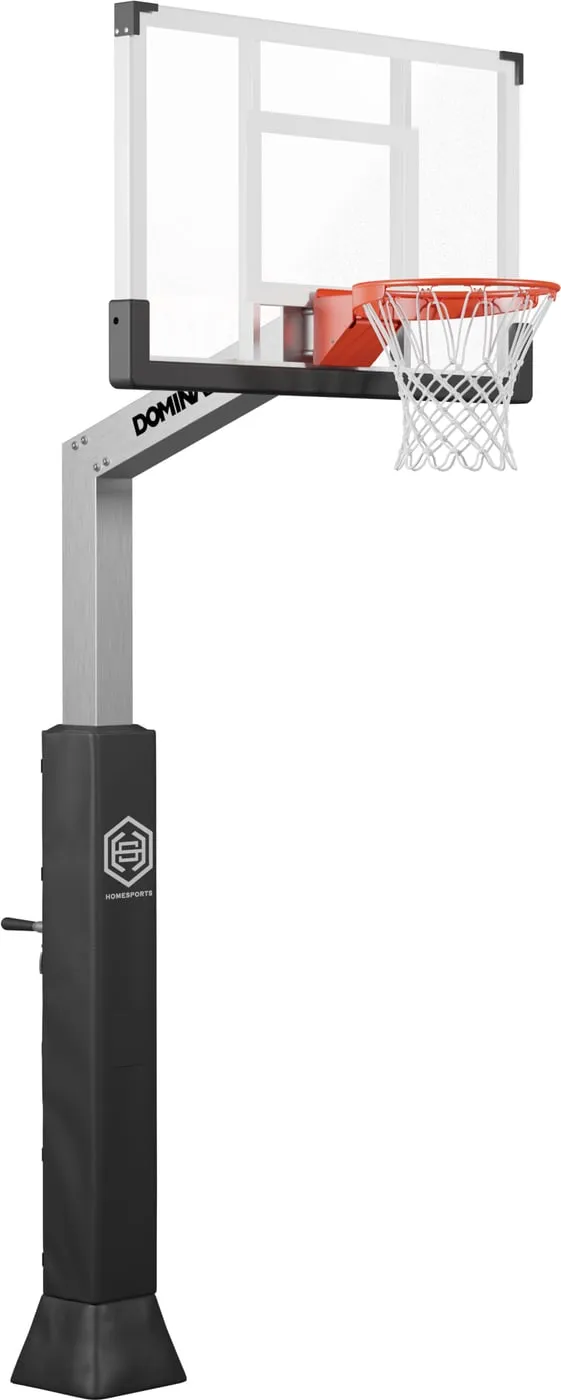 Dominator 54 inch glass hoop at three-quarter view, the smallest of the three glass backboards. Clear board with a black surround, orange breakaway rim, and a brushed aluminum square pole rising from a black padded post with the height crank low on its left side.