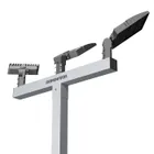 Close on the crossbar of a triple pole, the Dominator wordmark along the bar with three LED heads spaced across it.