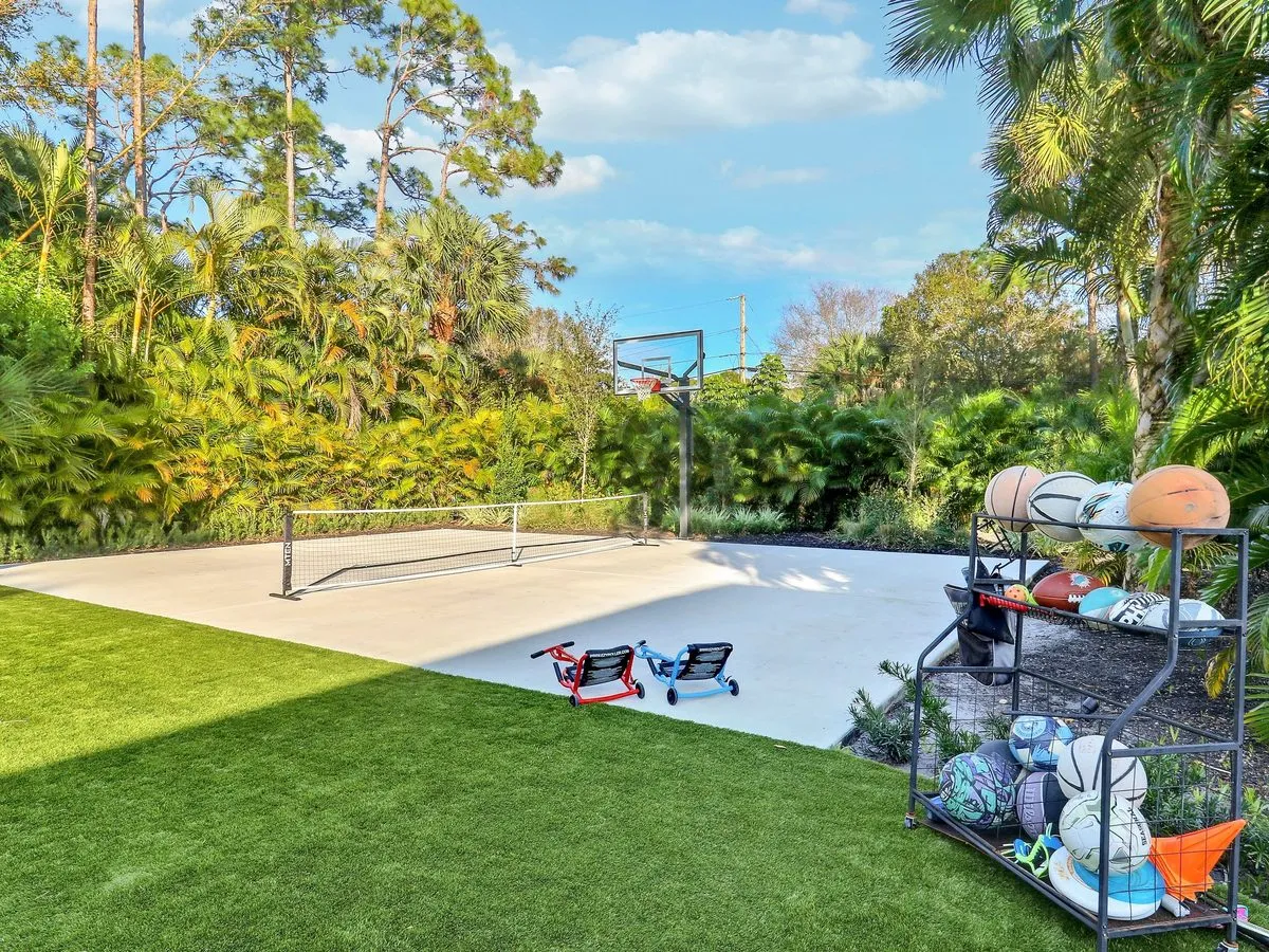 Backyard basketball court alongside a screened pool enclosure