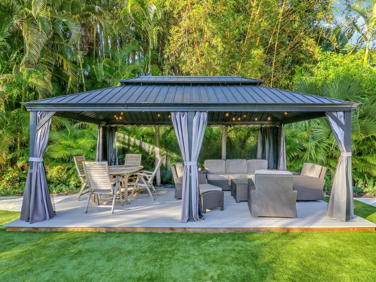 Turf lawn with an in-ground trampoline and a covered gazebo with seating